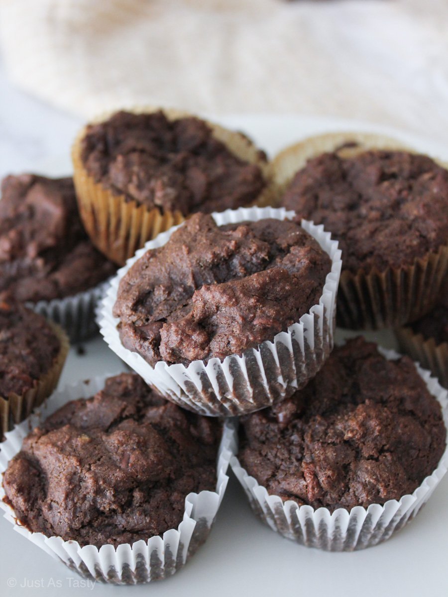 Gluten free chocolate muffins piled on a marble surface.