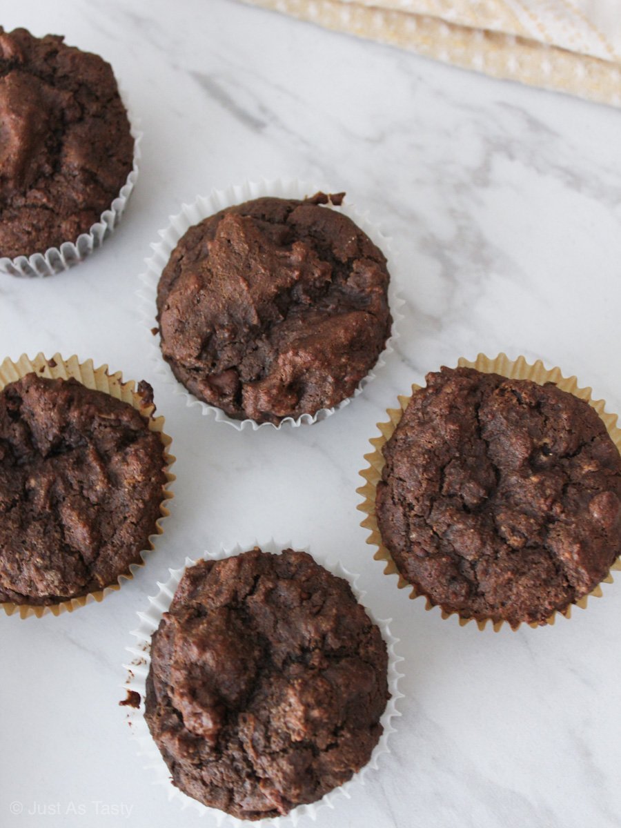 Gluten free chocolate muffins on a white marble surface.