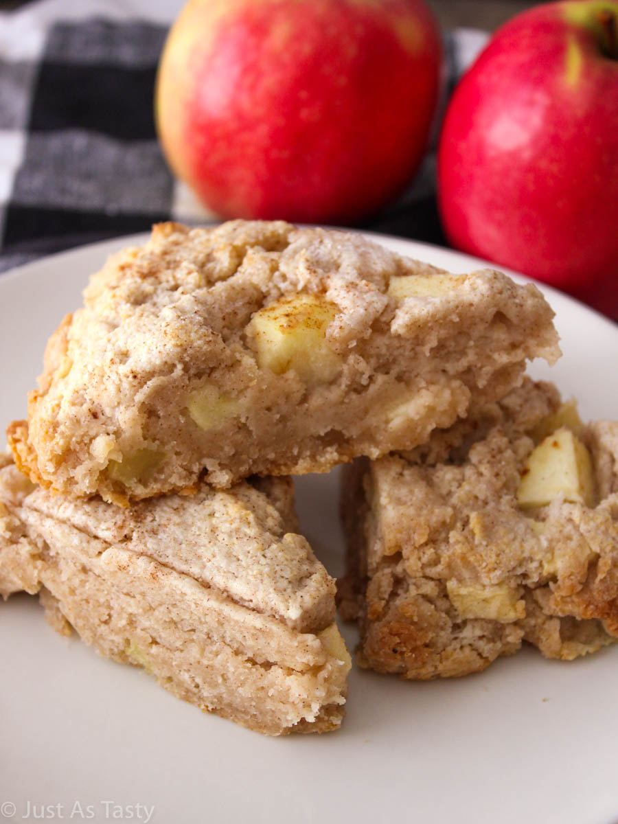 Apple cinnamon scones stacked on a white plate.