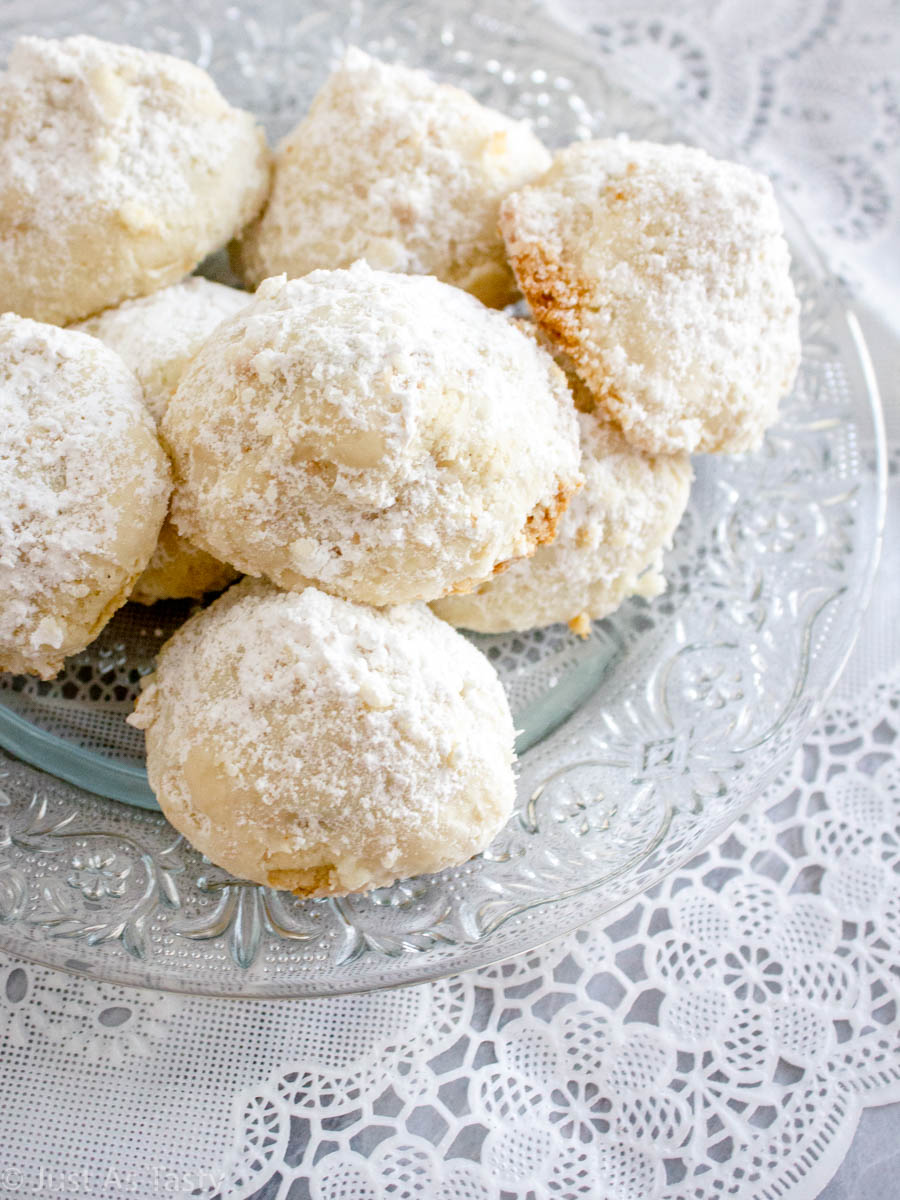 Chocolate snowball cookies on a glass plate.