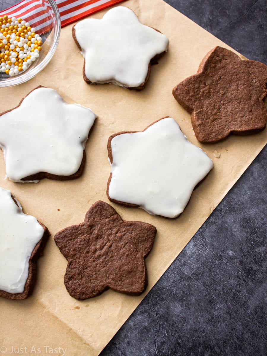 Star-shaped chocolate sugar cookies on brown parchment paper.