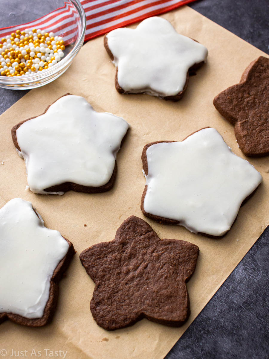 Star-shaped chocolate sugar cookies on brown parchment paper.