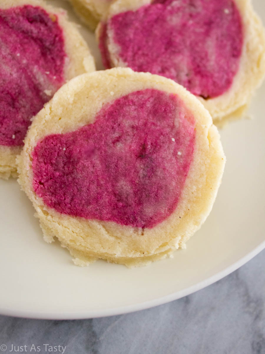 Close-up of slice and bake sugar cookie with a pink heart in the center.