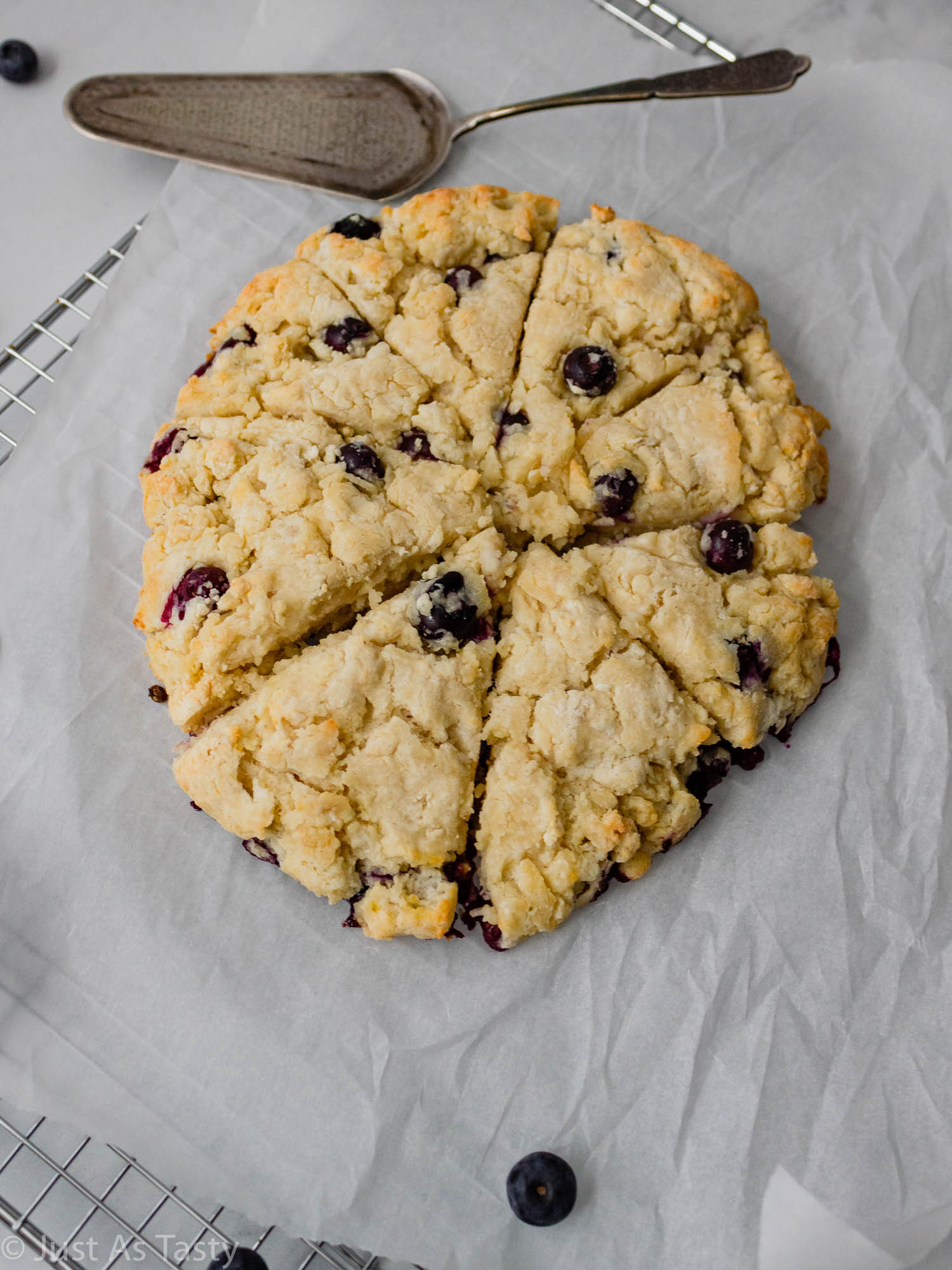 Blueberry scones on white parchment paper.