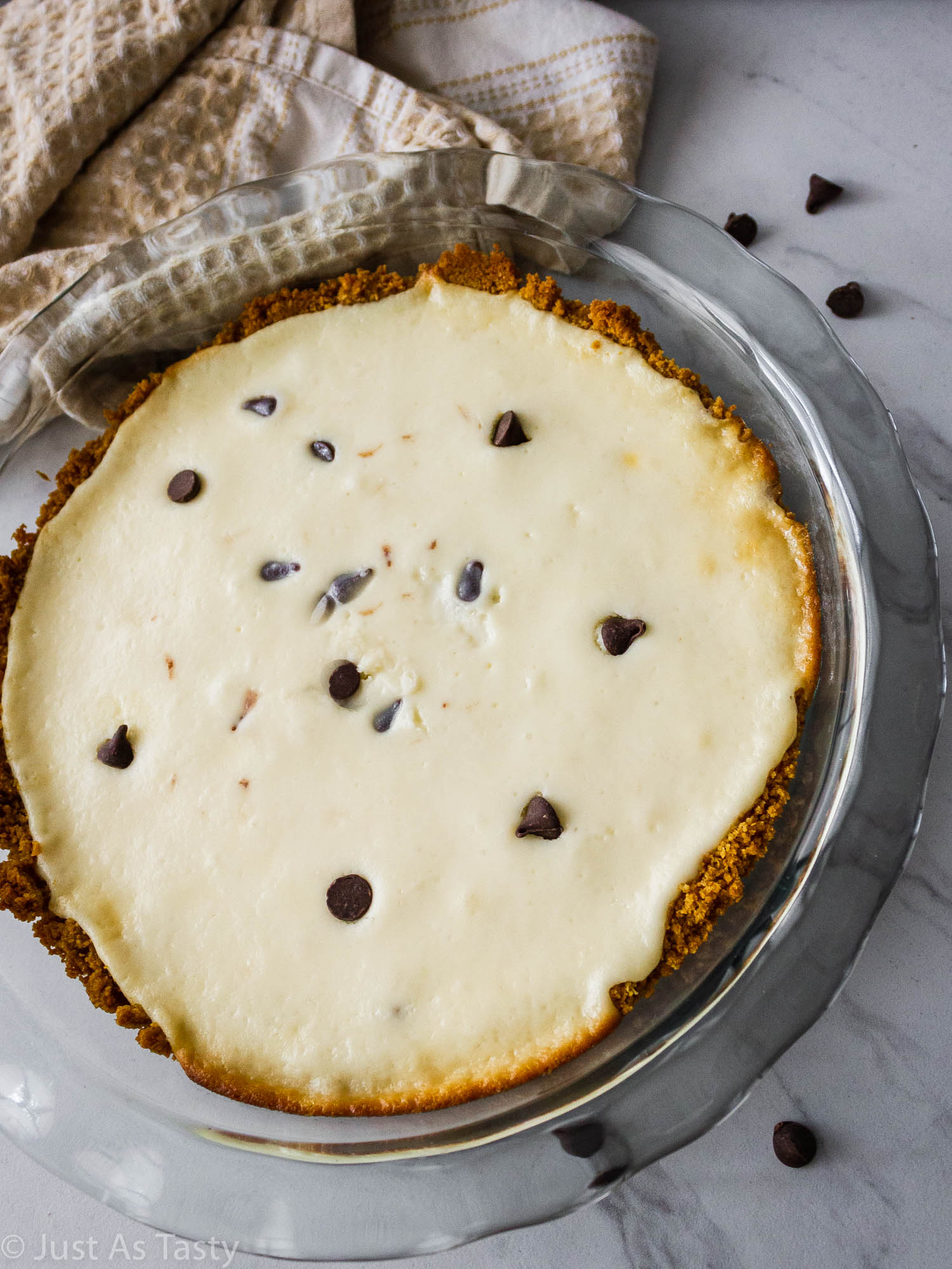 Cannoli pie topped with chocolate chips in a glass pie dish. 