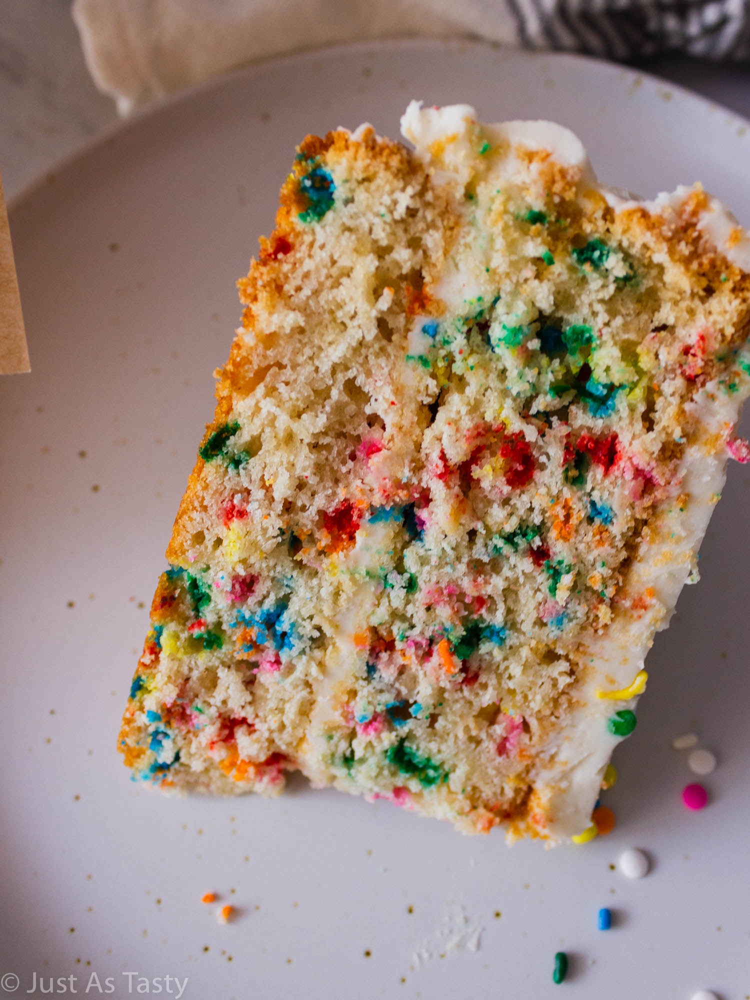 Close-up of a slice of funfetti cake on a plate. 