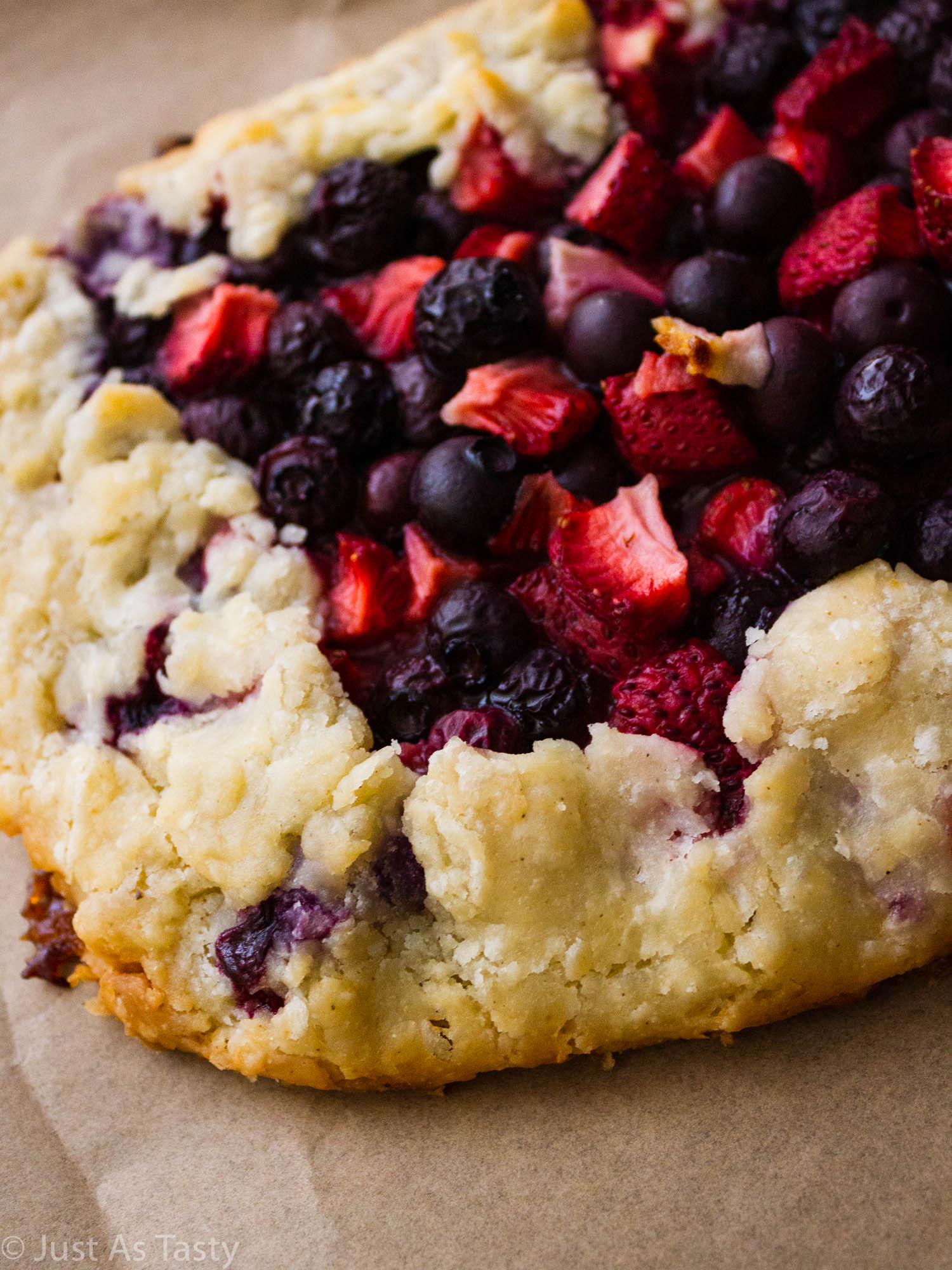 Close-up of a berry galette filled with strawberries and blueberries.
