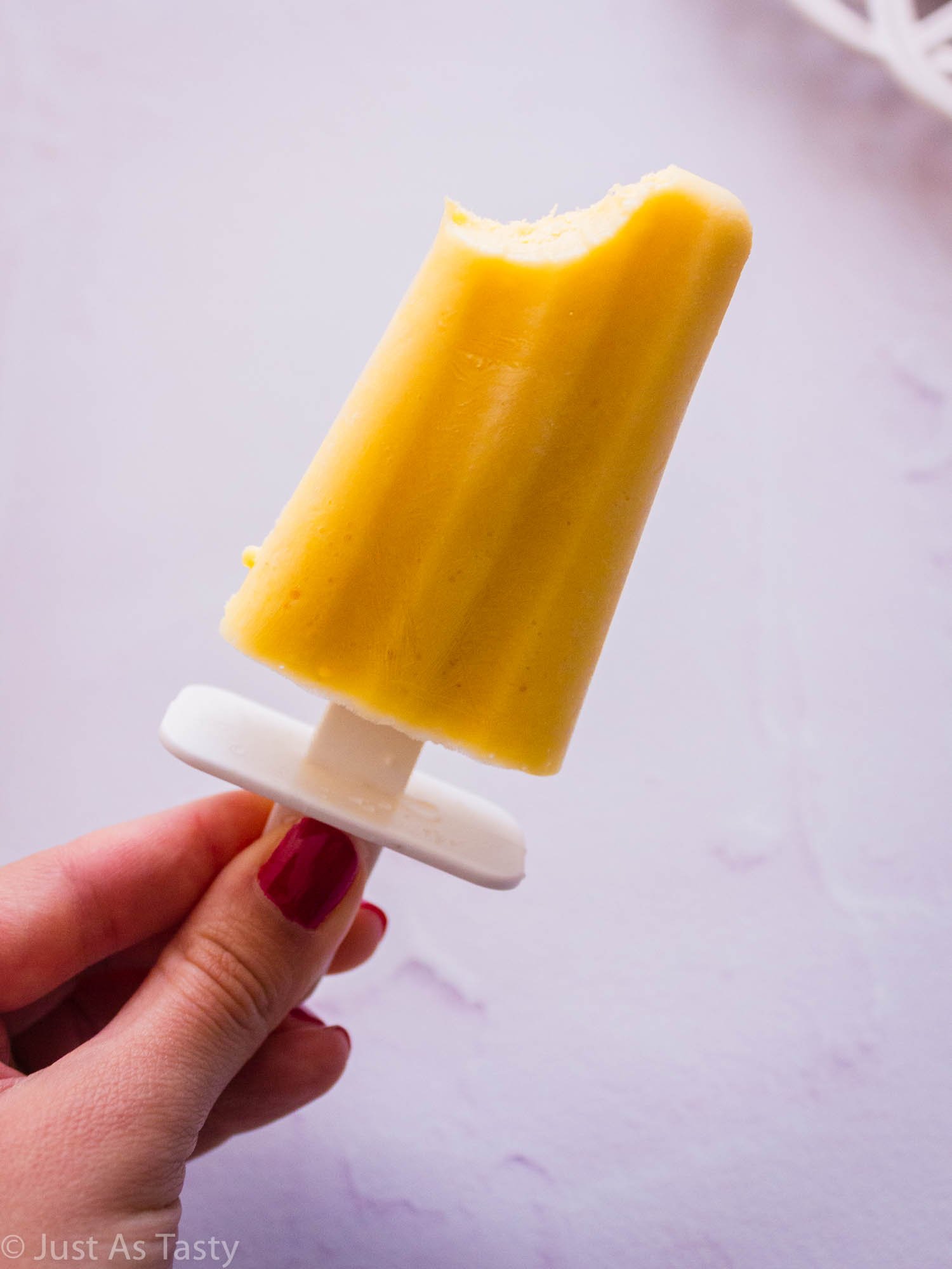 Mango creamsicle with a bite taken out of it. 