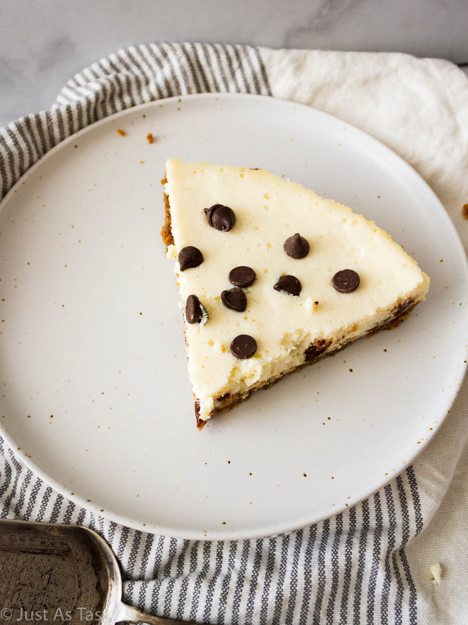 Slice of cheesecake topped with chocolate chips.
