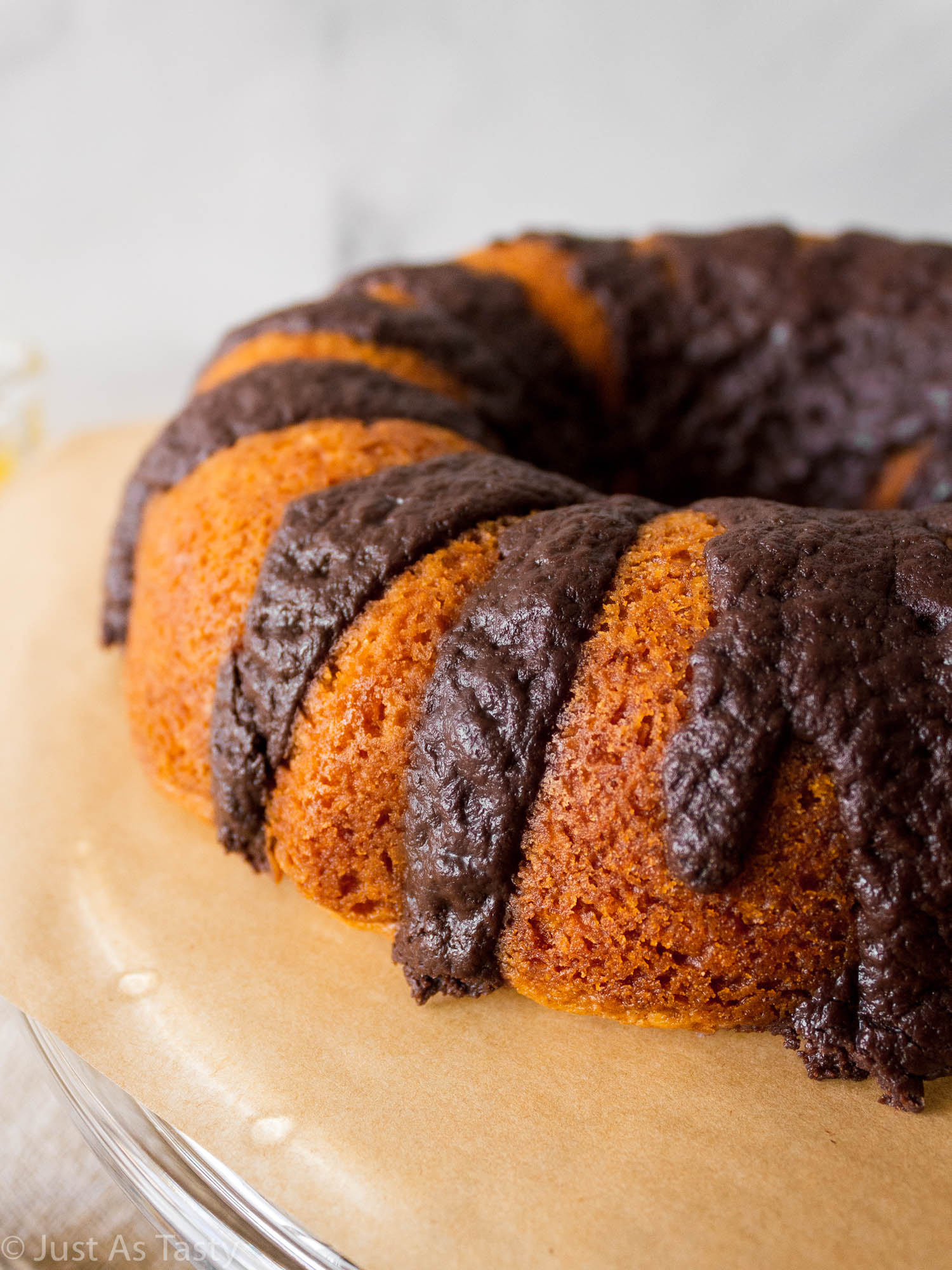 Close-up of orange bundt cake with chocolate glaze.