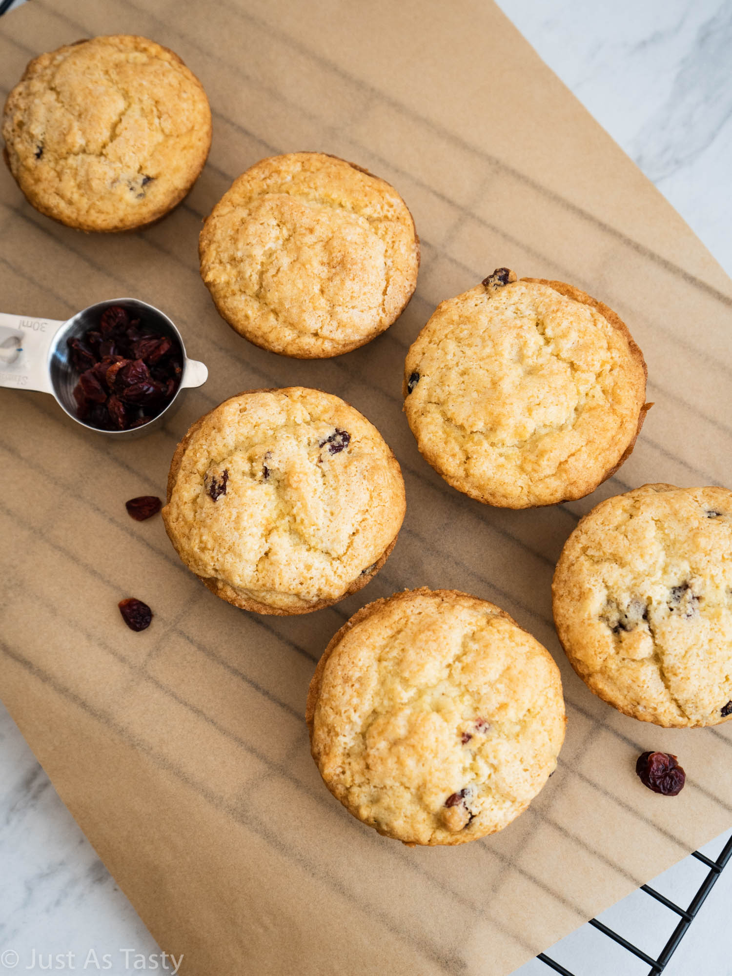 Jumbo cranberry orange muffins on brown parchment paper.