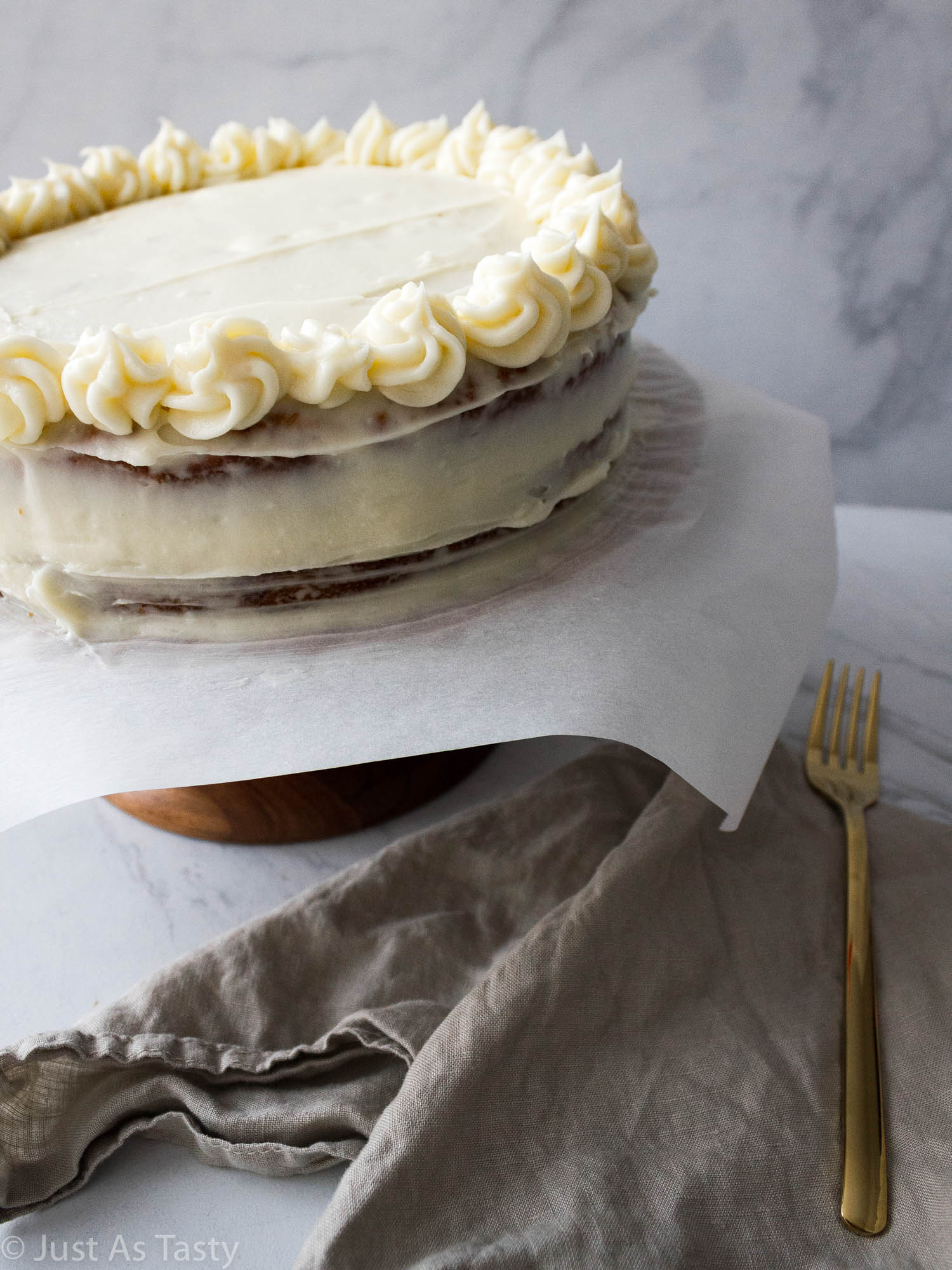 Frosted two layer cake on a cake stand.