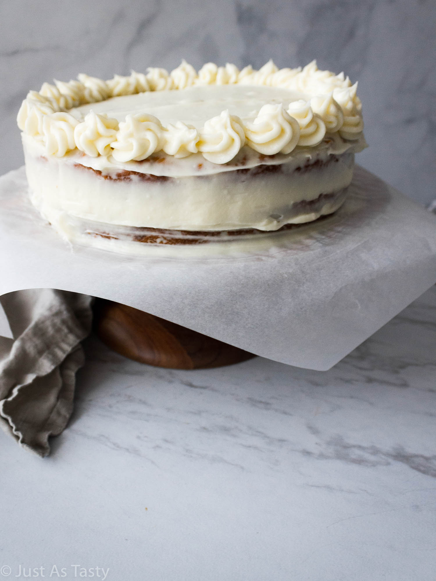 Frosted hummingbird cake on a cake stand. 