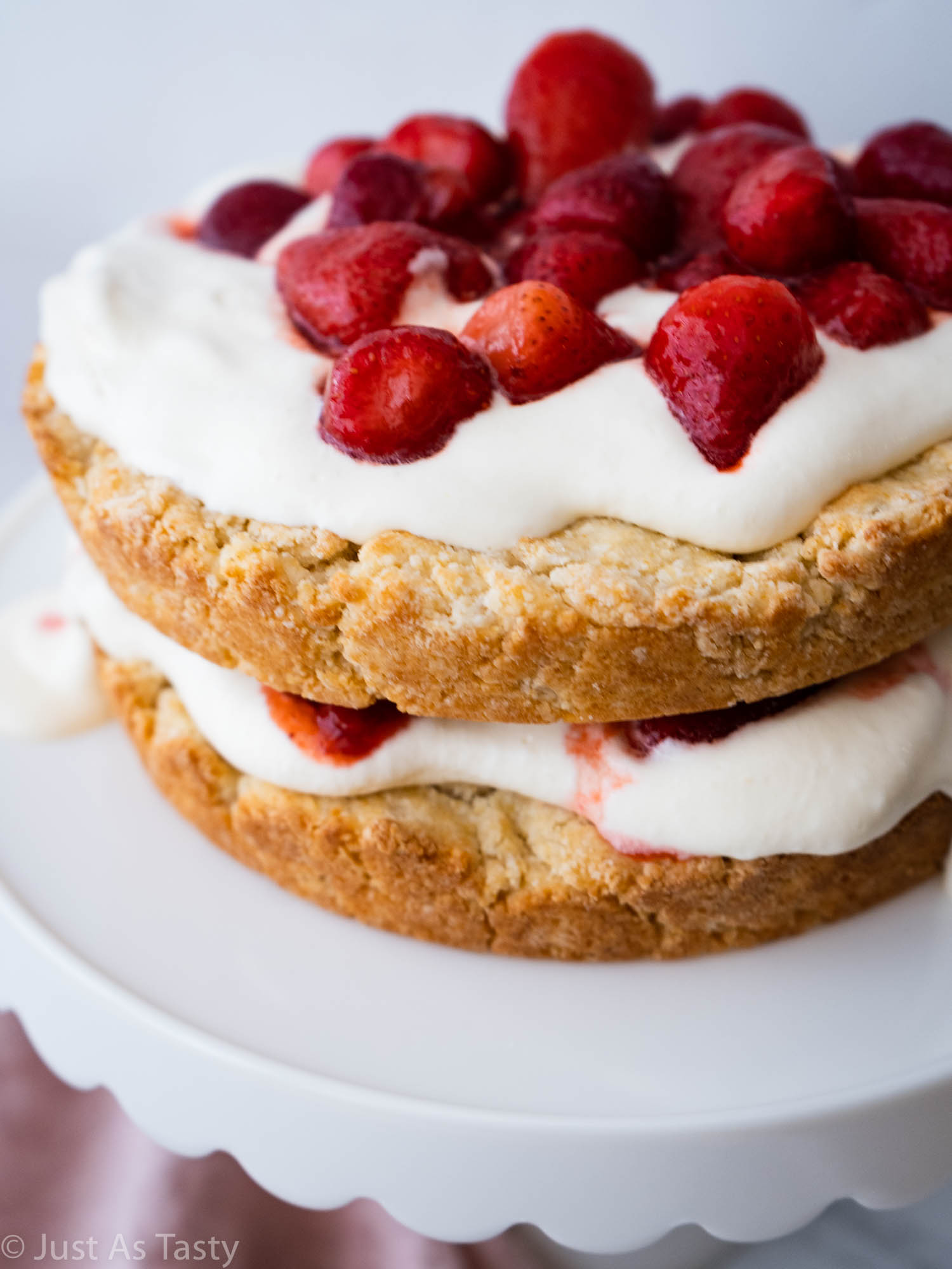 Gluten free strawberry shortcake on a white cake stand. 