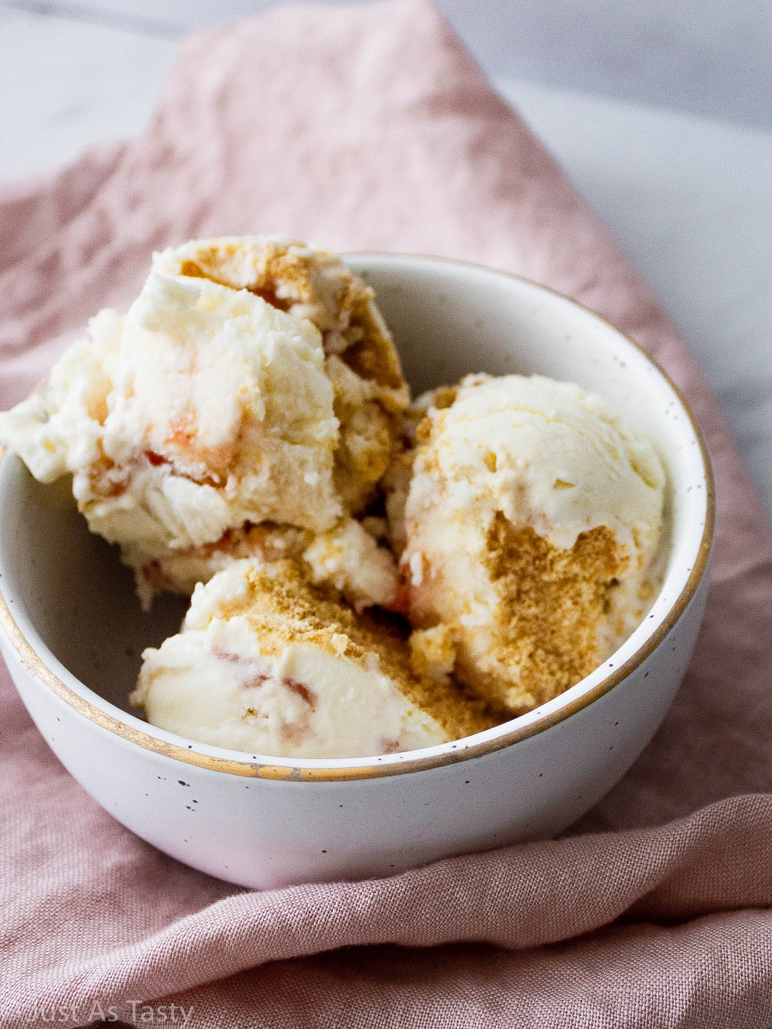Scoops of strawberry swirl ice cream in a bowl.
