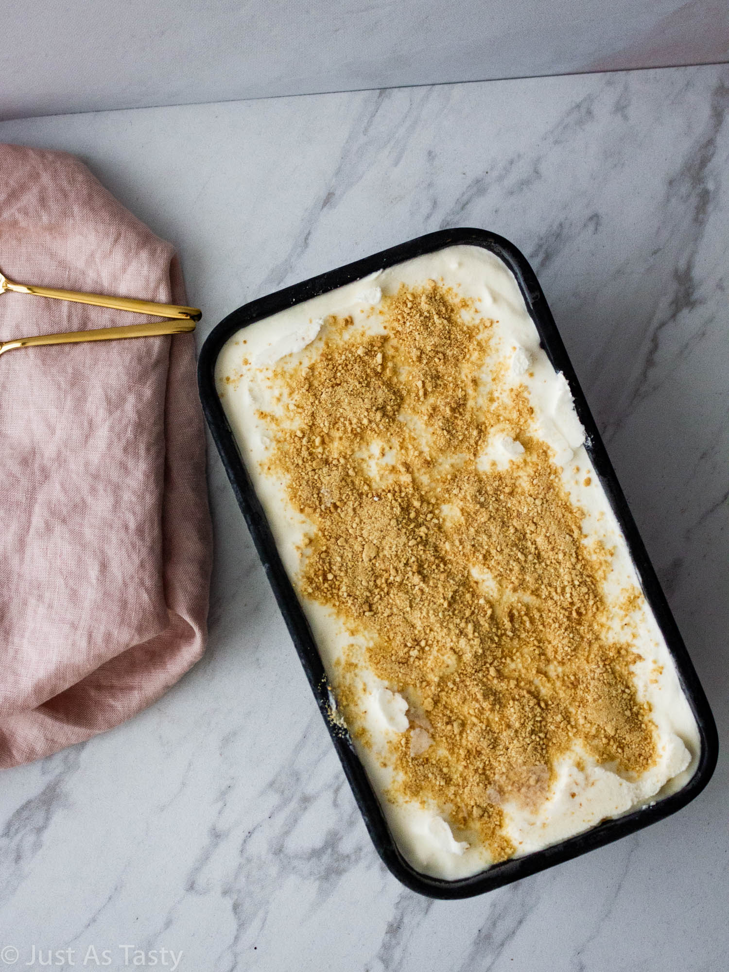 No-churn ice cream topped with graham cracker crumbs in a loaf pan.