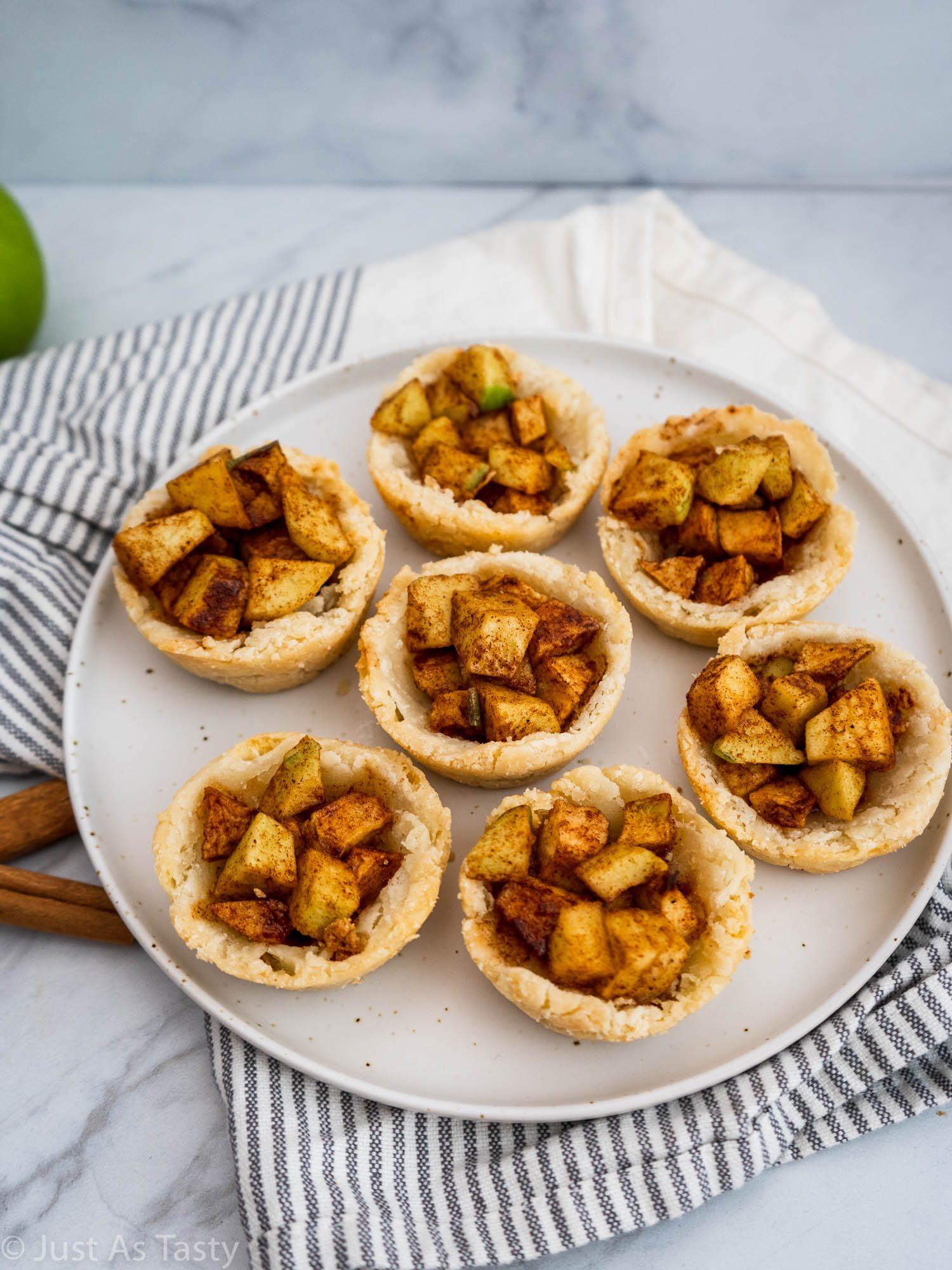 Muffin tin apple pies on a white plate. 